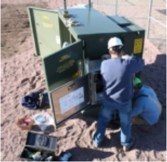 Jared VanDerWerff and Mike Dangel work to install the substation AMR equipment